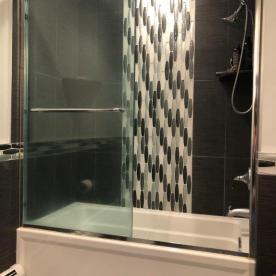 Soaking tub with glass waterfall effect inset
