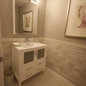 Powder room with marble wainscot and mosaic marble floor