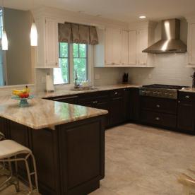 Two tone kitchen with six burner Wolf range and chimney style hood and glass backsplash